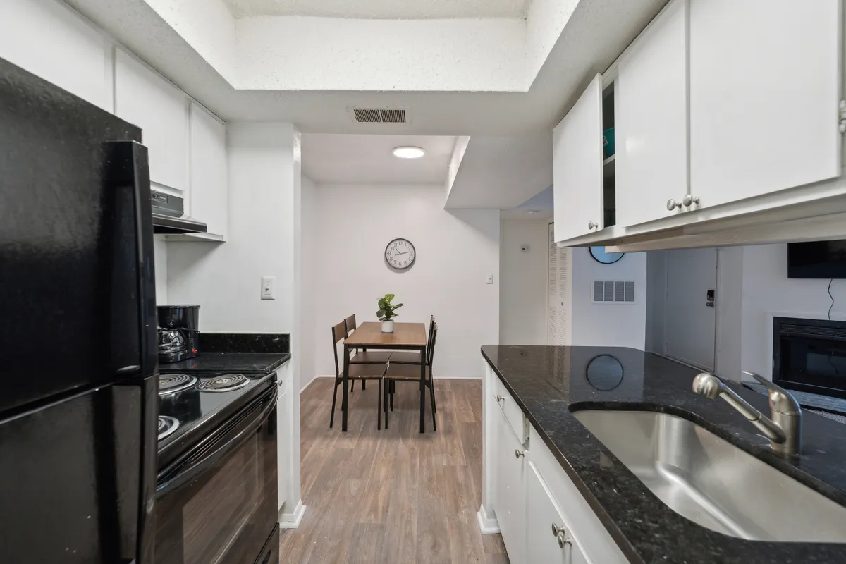 A cozy kitchen and dining area featuring modern appliances, a clean sink, and a table set for dining. The setup suggests both functionality and warmth, with everything needed for daily life already in place.